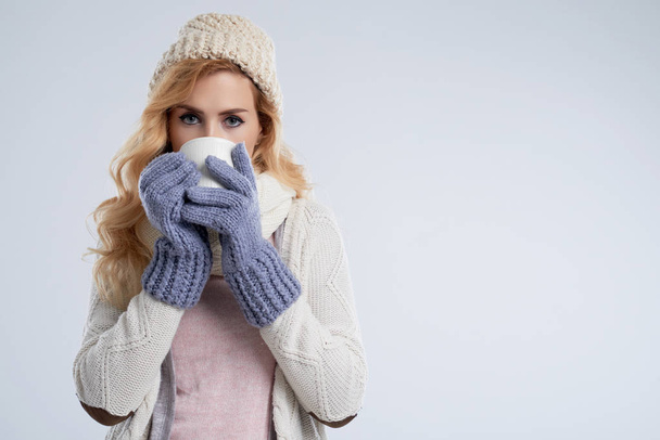 Portrait of pretty young woman in warm clothes drinking hot chocolate - Photo, Image