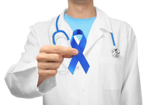 Doctor holding blue ribbon on white background, closeup. Prostate cancer awareness - Φωτογραφία, εικόνα