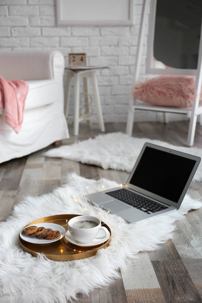 Tray with breakfast and laptop on fluffy carpet in room - Fotó, kép