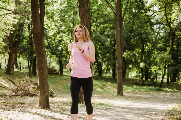 Sporty girl running in the park - Foto, afbeelding