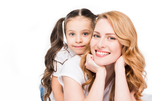 portrait of smiling mother and daughter looking at camera isolated on white - Valokuva, kuva