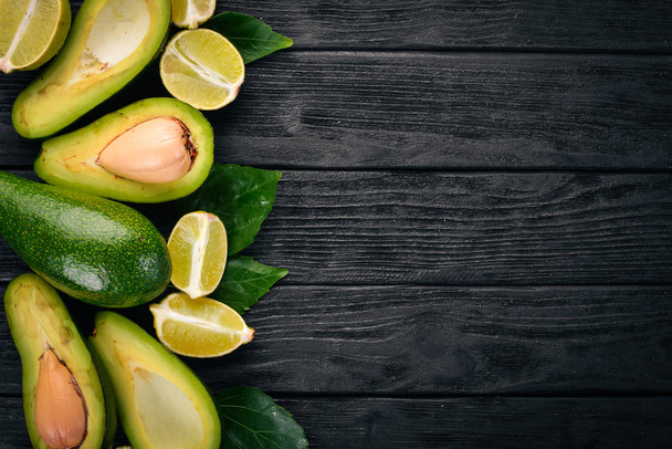 Avocado and lime on a wooden background. Top view. Free space for your text. - Foto, imagen