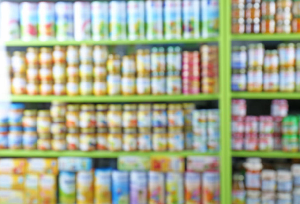 Vista borrosa de los estantes con comida para bebés en la tienda
 - Foto, imagen