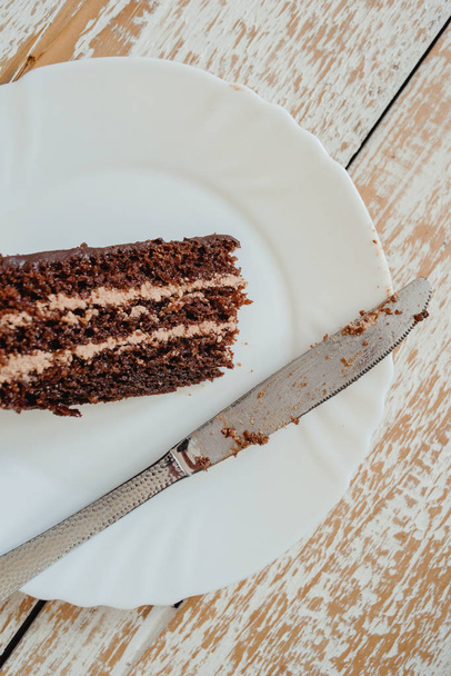 piece of chocolate cake on a white plate - Foto, afbeelding