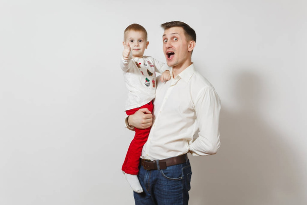 Happy Father's Day. Handsome joyful smiling young man holding and hugging little cute child boy isolated on white background. Father and his little kid son. Parenthood, family and children concept. - Photo, Image