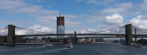 Circle line and other tour boats heading under the Brooklyn Brid - 写真・画像