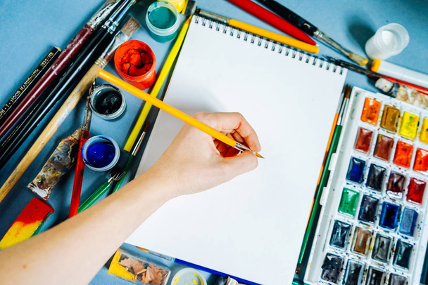 woman painter paints colorful paints on a white sheet of paper - Photo, Image