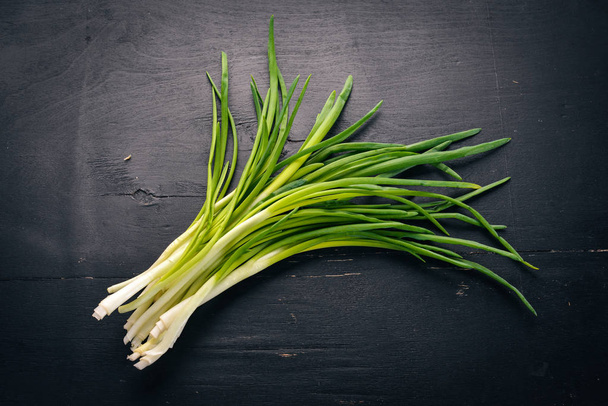 Fresh green onion on a wooden background. Top view. Free space for your text. - Foto, afbeelding