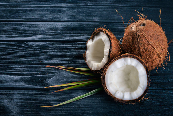 Coconut on a wooden background. Tropical fruits and nuts. Top view. Free space for text. - Valokuva, kuva