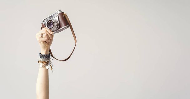 Vrouw arm opgewekt houden camera geïsoleerd achtergrond - Foto, afbeelding