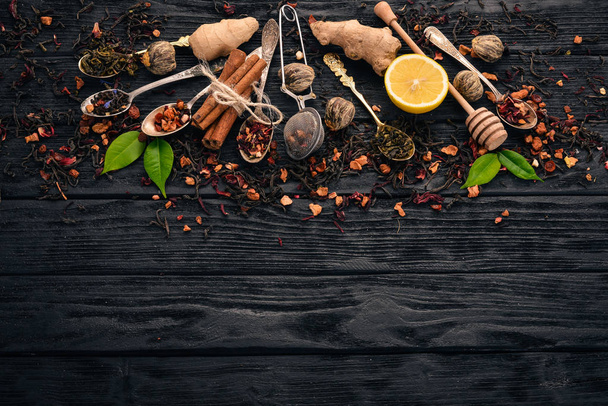 Assortment of dry teas and fragrant herbs and spices. On a wooden background. Top view. Copy space. - Zdjęcie, obraz