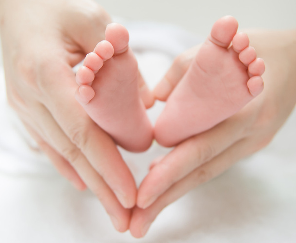 Pieds nouveau-nés sur les mains féminines
 - Photo, image