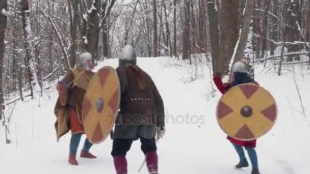 Medieval frankish, irish, viking warriors in armor fighting in a winter forest with swords shields - Footage, Video