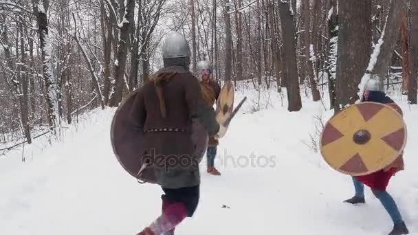 mittelalterliche fränkische, irische, Wikinger-Krieger in Rüstungen, die in einem Winterwald mit Schwertschilden kämpfen - Filmmaterial, Video