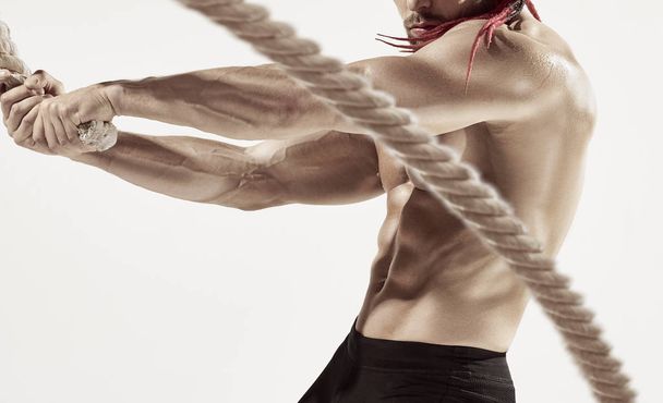 Attractive muscular man working out with heavy ropes. - Valokuva, kuva
