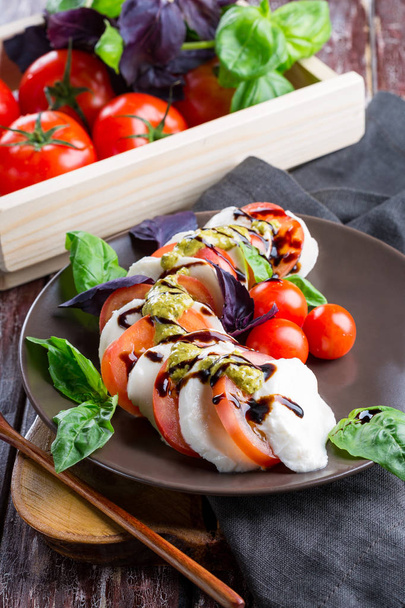 Caprese, Italiaanse keuken, kaas, tomaten, kruiden, basilicum, pesto - Foto, afbeelding