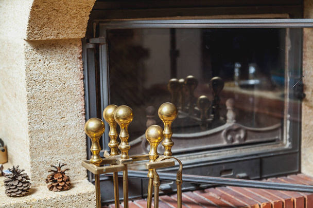 set of brass tools stands in front of fireplace - Foto, immagini