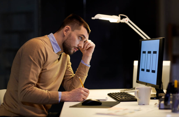 man with notepad working at night office - Zdjęcie, obraz