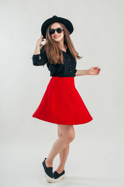 Young beautiful fashionable woman with trendy makeup  in black hat and glasses on the grey background . Model looking at camera, wearing stylish eyeglasses. Female fashion, beauty concept.  - Photo, image