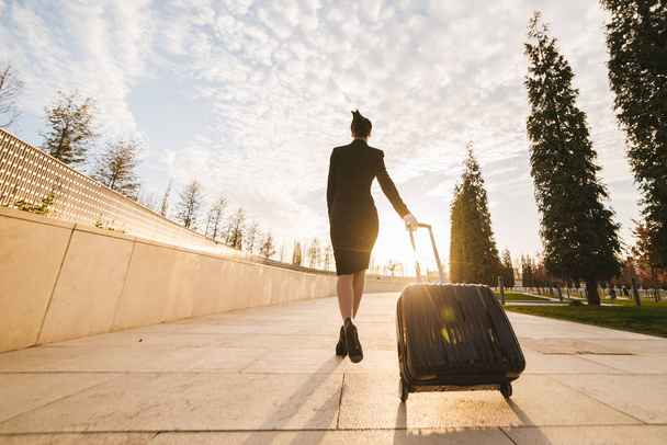 woman in flight stewardess carries a large suitcase - 写真・画像