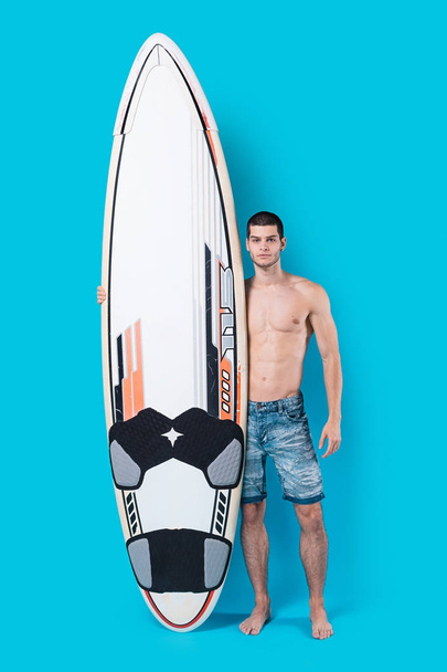 Kendine güvenen sörfçü bir surfboard holding - Fotoğraf, Görsel