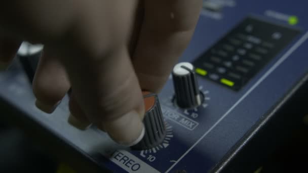 dedos femininos girando botão fader no mixer de áudio
 - Filmagem, Vídeo