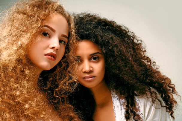 Portrait of two curly girls. Afro and blond - Foto, Imagem