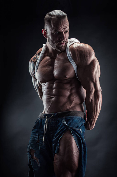 Porträt eines starken, athletischen Fitness-Mannes, der große Muskeln zeigt - Foto, Bild