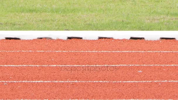 Koşu bandı Stadı nda kırmızı zemin lastik üzerinde beyaz çizgi. - Video, Çekim