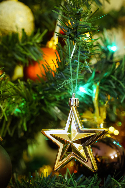 Nahaufnahme isolierter Stern am Weihnachtsbaum mit blauem Hintergrund - Foto, Bild