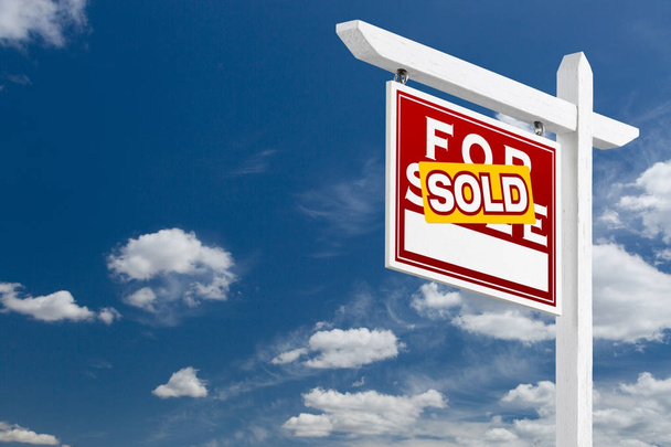 Left Facing Sold For Sale Real Estate Sign Over Blue Sky and Clouds With Room For Your Text. - Photo, Image