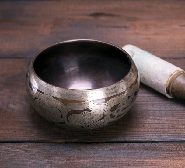 copper singing bowl and a wooden stick  - Foto, afbeelding