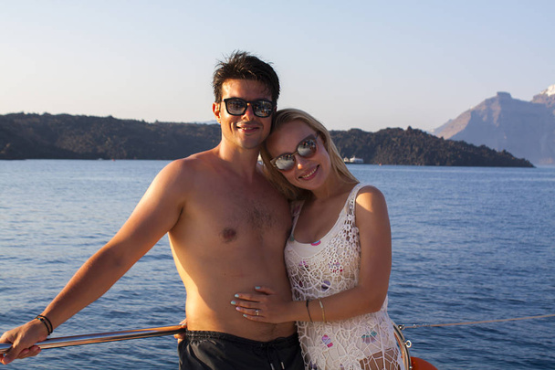 Couple romantique sur le yacht au coucher du soleil. Excursion en bateau à Santorin
 - Photo, image