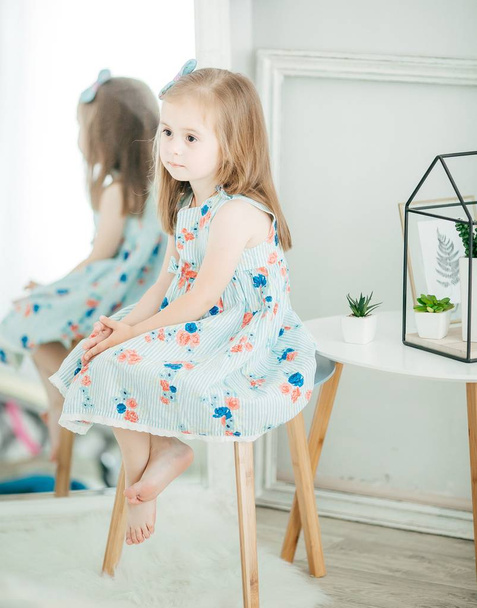 Το χαριτωμένο μικρό κορίτσι στο φόρεμα στο σπίτι, ευτυχισμένη παιδική ηλικία έννοια - Φωτογραφία, εικόνα