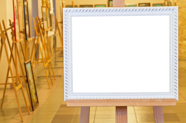 weißer Bilderrahmen auf Staffelei in der Galeriehalle - Foto, Bild