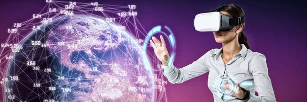 Female executive using virtual reality headset against pink and purple background - Фото, изображение