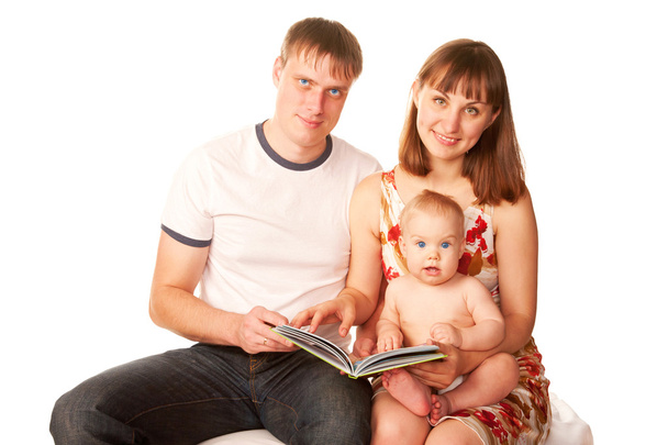 Щаслива сім'я читає книгу і посміхається
. - Фото, зображення
