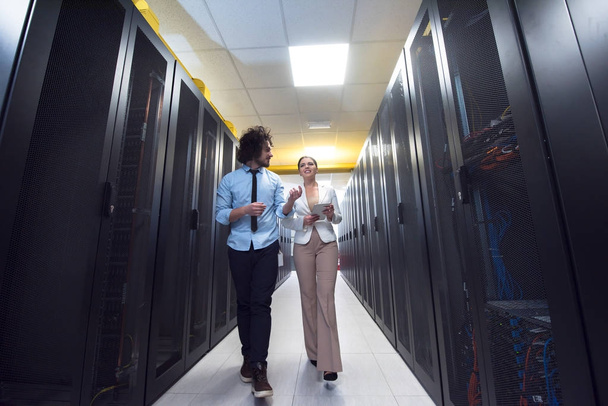 engineer showing working data center server room to female chief - 写真・画像