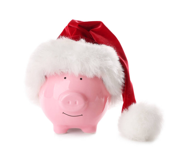 Piggy bank with Santa hat on white background - Foto, afbeelding