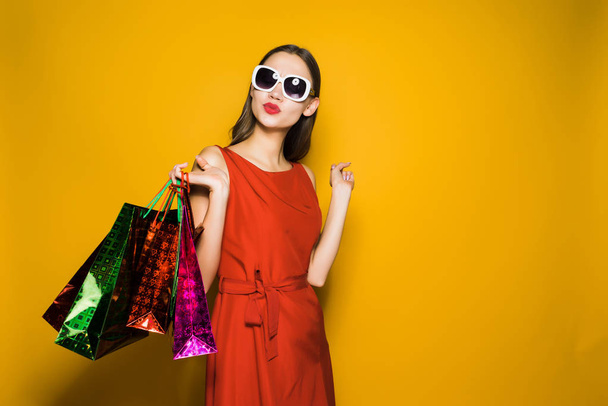 Kobieta piękna czerwona sukienka trzyma torby na zakupy - Zdjęcie, obraz