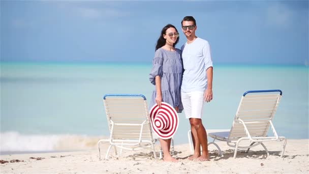 Νεαρό ζευγάρι στην παραλία με λευκή κατά τη διάρκεια των θερινών διακοπών. Ευτυχισμένη οικογένεια να απολαύσετε το γαμήλιο ταξίδι τους - Πλάνα, βίντεο