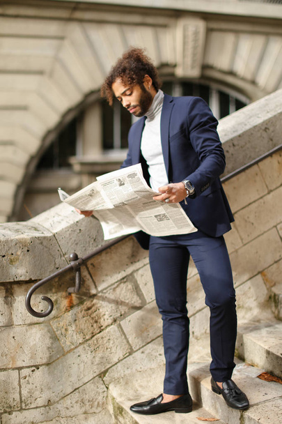 Young male model reading newspaper on open air. - Foto, Imagem