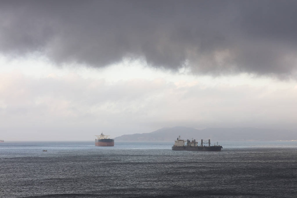 Myrskytaivas Gibraltarin sataman ankkuripaikan yllä
 - Valokuva, kuva
