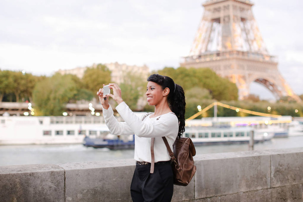 Młoda kobieta stojąc na nasyp w Paryżu i oglądanie zdjęć - Zdjęcie, obraz