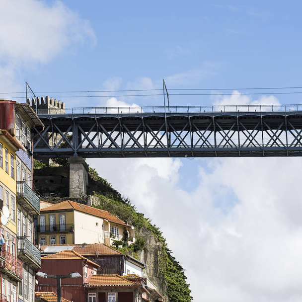 Eiffelin rakentama silta Porton historiallisen keskustan taustalla perinteisillä portugalilaisilla julkisivuilla, jotka on joskus koristeltu azulejon keraamisilla laatoilla
 - Valokuva, kuva