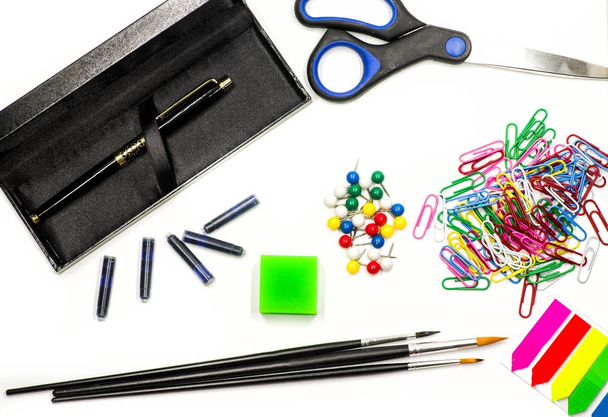 office supplies on white. ink pen, brushes, scissors, pencils, eraser, paper clips and bookmarks on white. writing and drawing tools - Photo, Image
