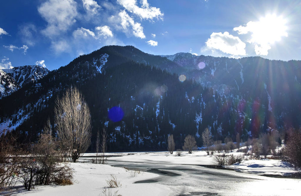 Winter in mountains. Star effect of the sun. Tian Shan, Almaty, Kazakhstan. - Foto, Imagem