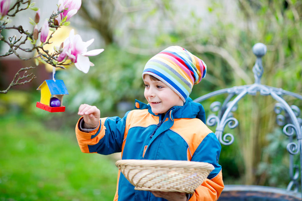 Милий чарівний маленький хлопчик робить полювання на яйце на Великдень
. - Фото, зображення