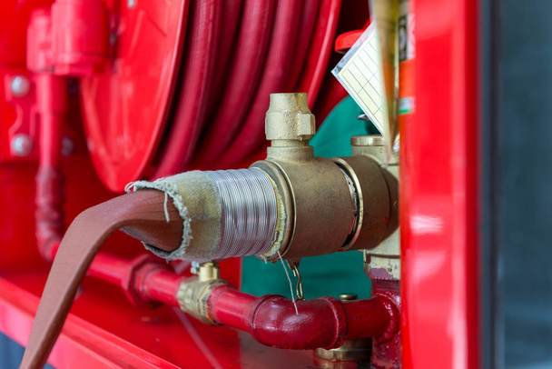 клапан насоса высокого давления с пожарным шлангом к шкафу на стене
 - Фото, изображение