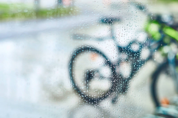 View of parked bicycles through the glass with drops of water - Valokuva, kuva
